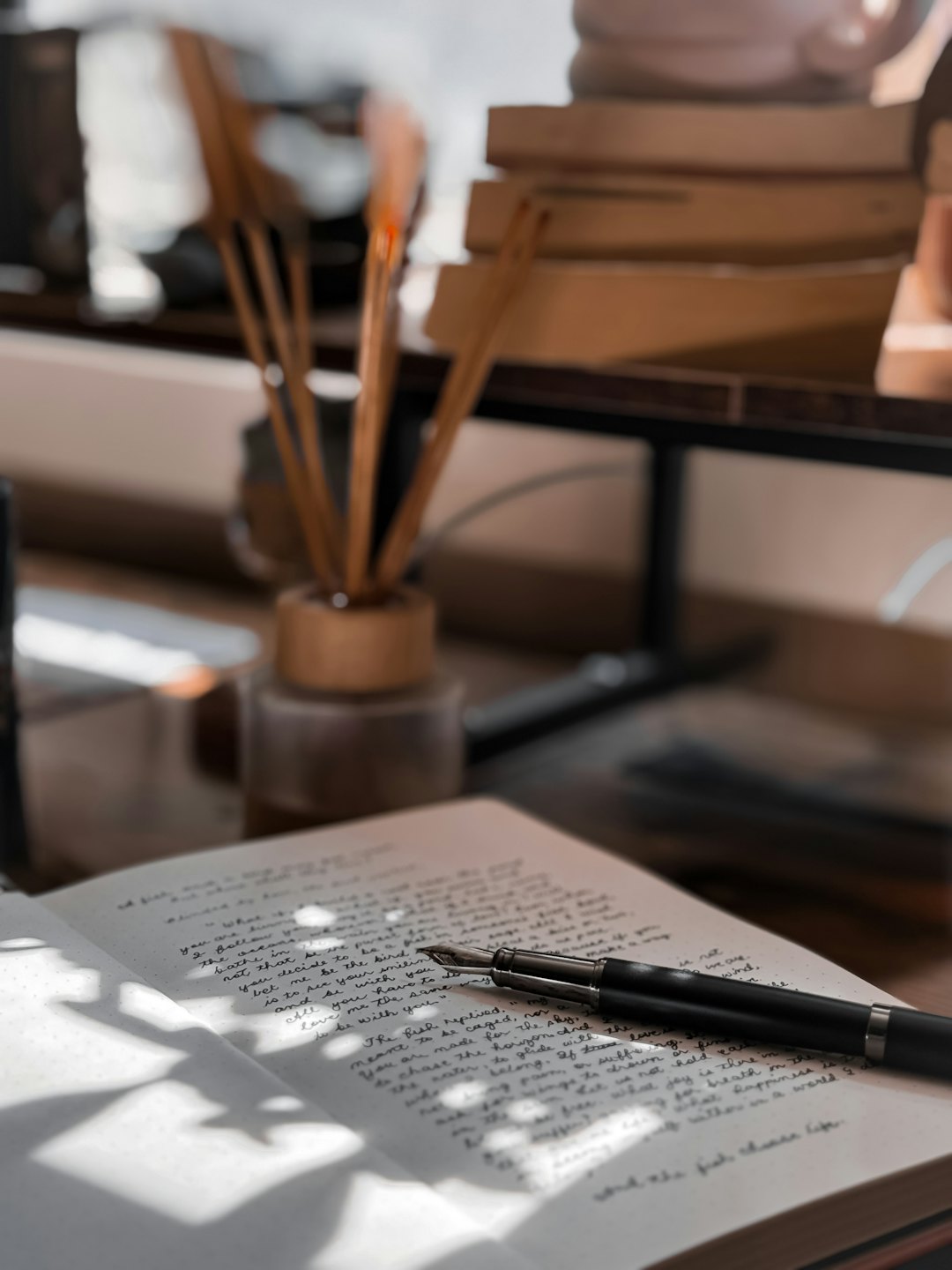 Handgeschreven dagboek en vulpen op een houten bureau.